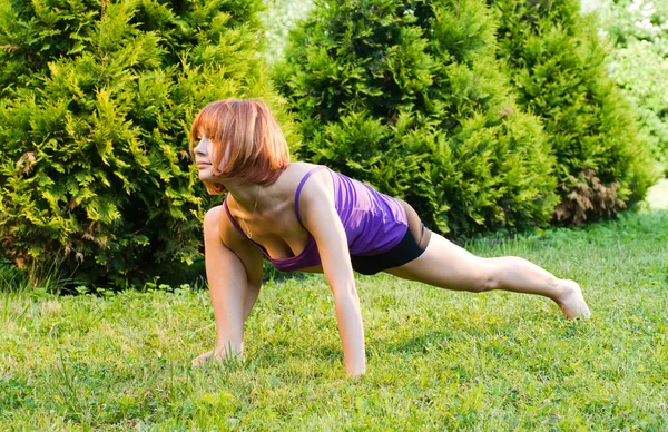 Красивая красная женщина занимается фитнесом или йогой — стоковое фото