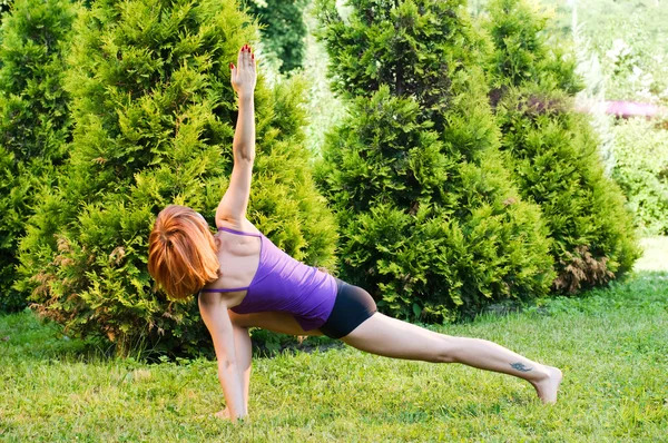 Güzel bir kırmızı kadın fitness ya da yoga exerci yapıyor — Stok fotoğraf