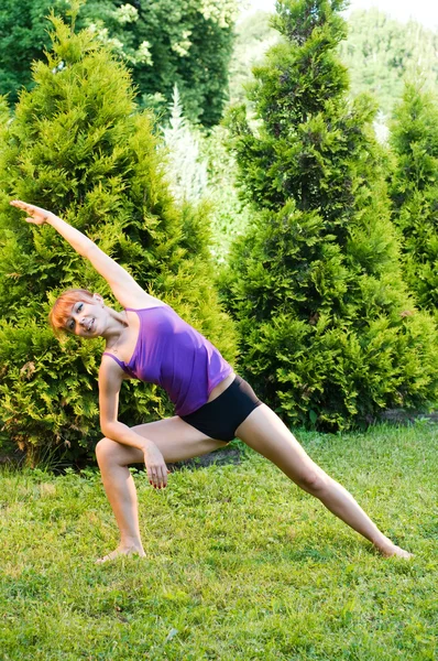 Güzel bir kırmızı kadın fitness ya da yoga exerci yapıyor — Stok fotoğraf