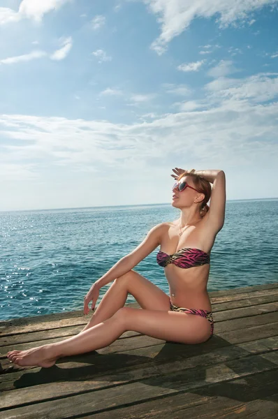 Sexy rode meisje dragen van bikini op de pier — Stockfoto
