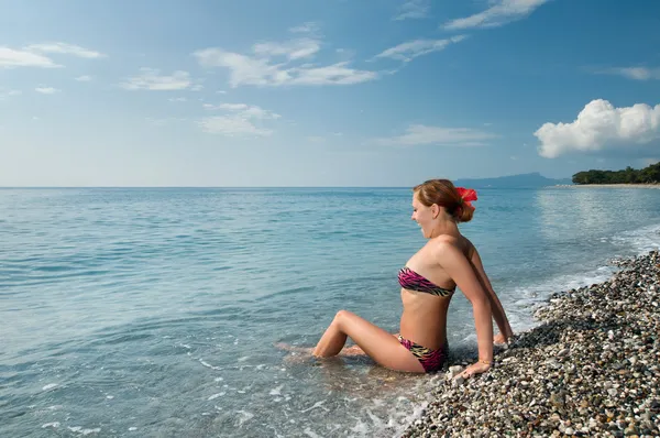 Sexy chica roja con bikini en la playa de guijarros — Foto de Stock