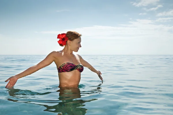 Sexig röd flicka klädd i bikini stående i havet — Stockfoto