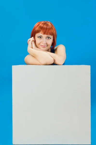 Red girl with blank board over blue background — Stock Photo, Image