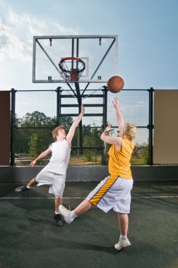 Teenagers playing streetball clipart