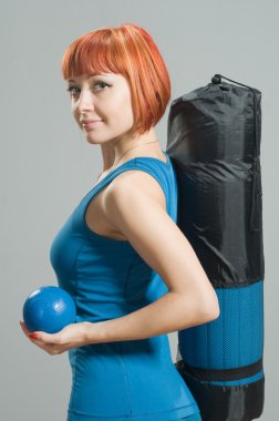 Red-haired fitness girl with yoga mat clipart