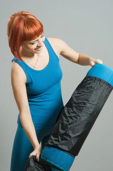 Рудий фітнес дівчина з йога килимок — стокове фото