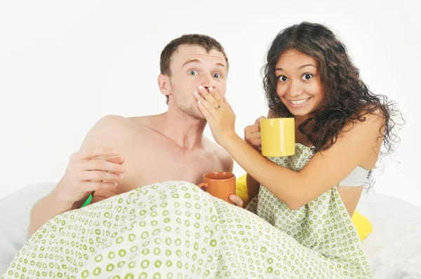 Ungt par förvånad i sängen — Stockfoto