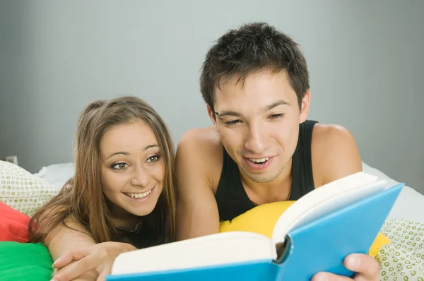 Счастливая пара читает книгу — стоковое фото