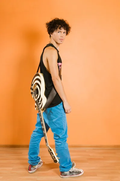 鮮やかな背景で若いギタリスト — ストック写真