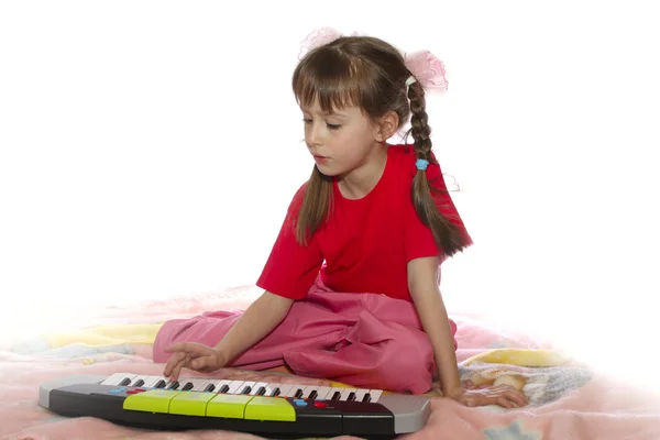 A menina com um sintetizador de brinquedos Fotos De Bancos De Imagens