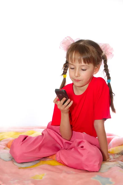 A menina brinca com um telefone celular Fotos De Bancos De Imagens