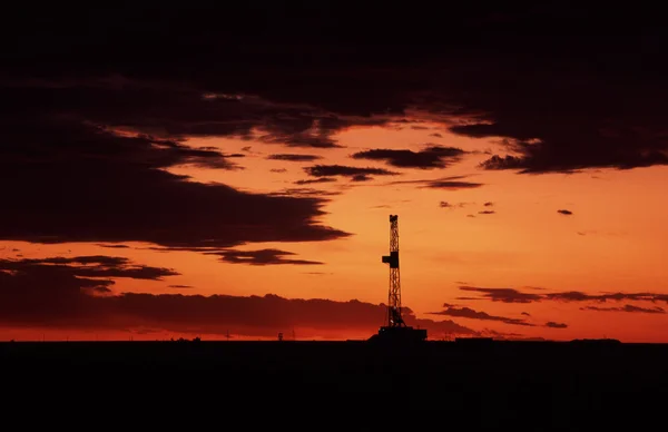 日落时的石油钻机 图库图片