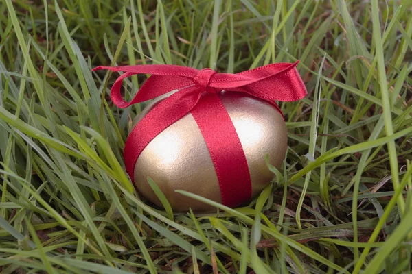 Çimenlerin üzerinde altın Paskalya yortusu yumurta — Stok fotoğraf