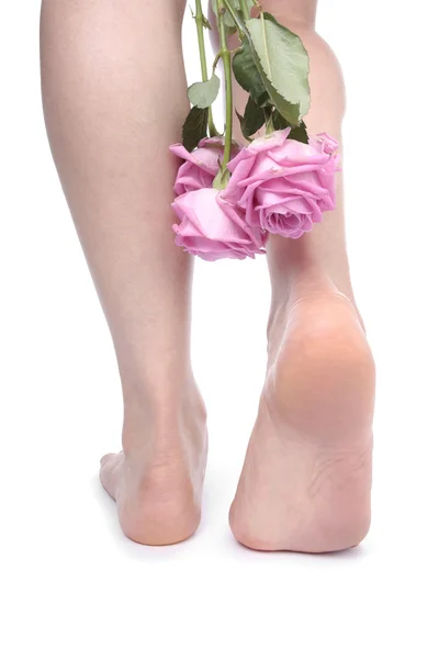 Kvinna fötter och blommor över vita — Stockfoto