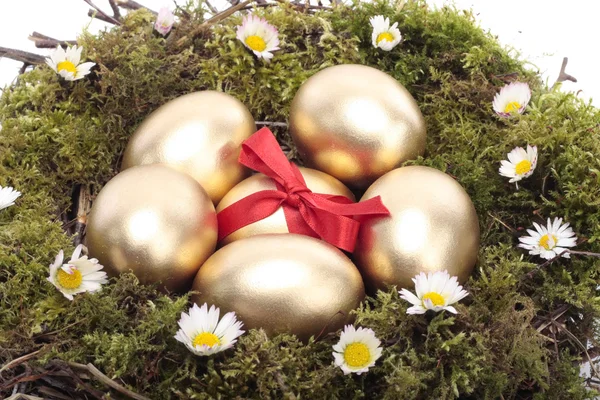 Huevos de Pascua dorados en nido de aves blanco aislado — Foto de Stock