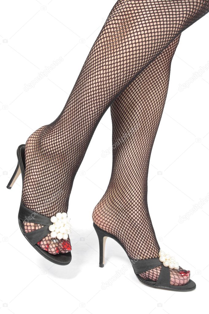Woman legs fishnet tights with heels over white