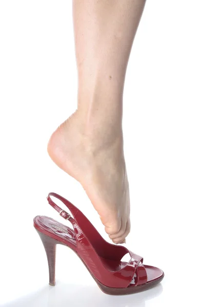 Bella donna piedi mettendo su scarpe tacco rosso — Foto Stock