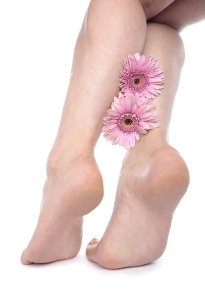 Pieds de femme jambes et fleurs sur blanc — Photo