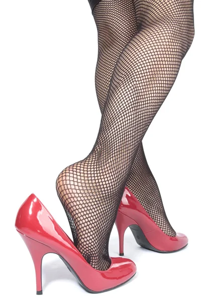 Bella donna gambe collant con tacchi rossi su bianco — Foto Stock