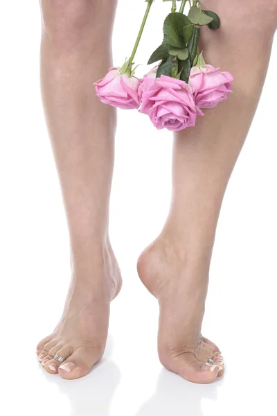Nő láb láb és a virágok felett fehér háttér — Stock Fotó