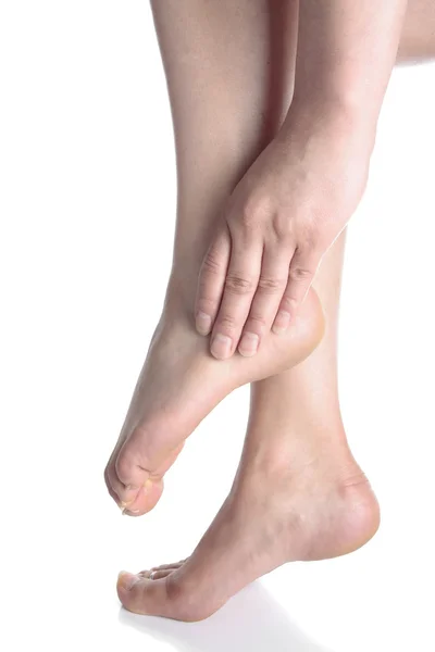 Žena masíruje bolavé nohy nad bílým pozadím — Stock fotografie