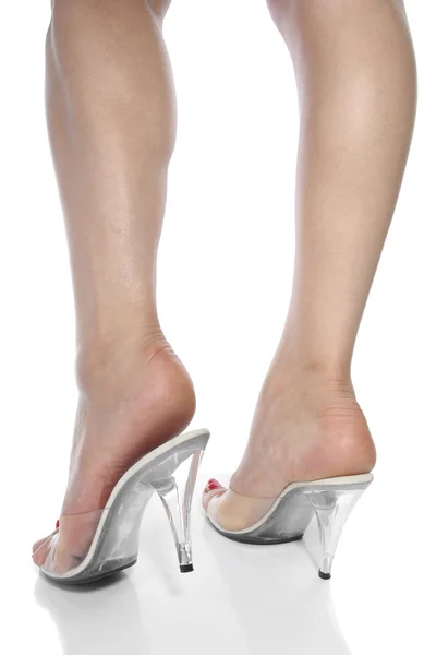 Mulher pés vestindo sapatos de salto vermelho sobre fundo branco — Fotografia de Stock