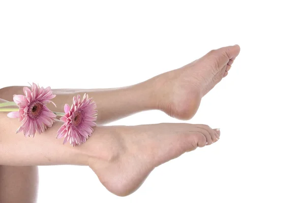 Frau Füße Beine und Blumen auf weißem Hintergrund — Stockfoto