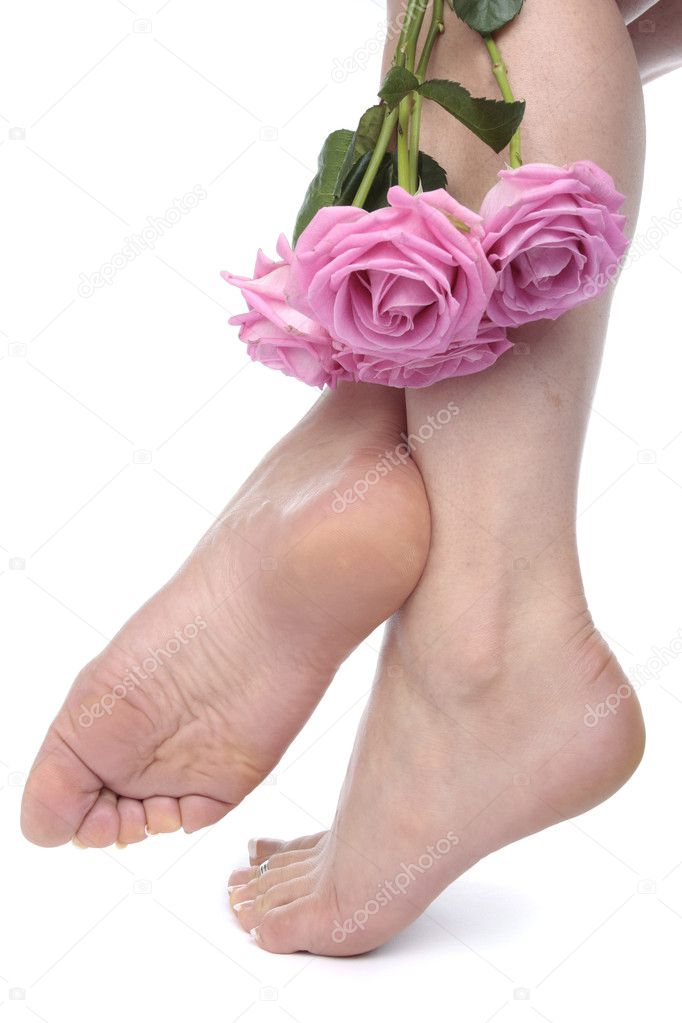 Woman feet and flowers over white background