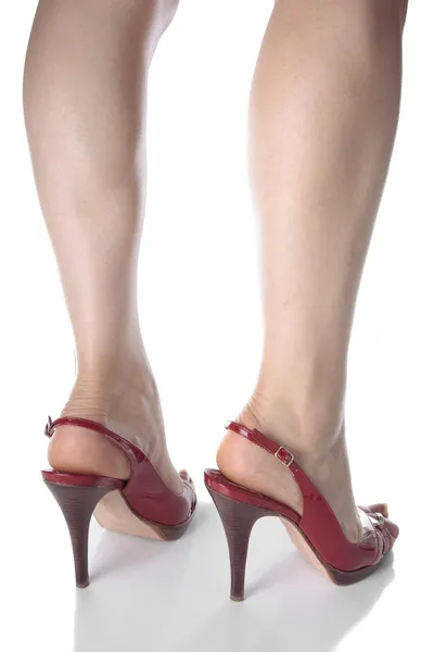 Kadın bacakları ve beyaz üzerine kırmızı topuk ayakkabı — Stok fotoğraf