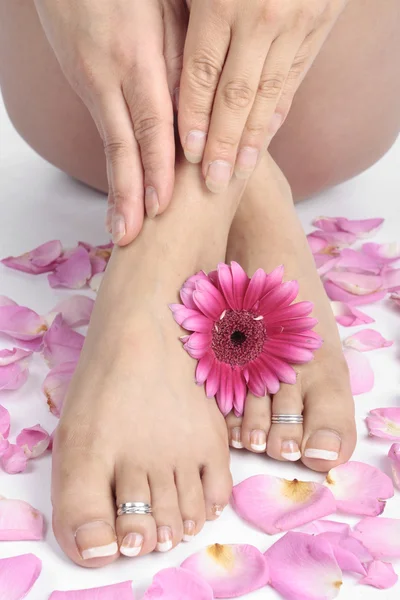 Kadın bacakları ve beyaz arka plan üzerinde çiçekler — Stok fotoğraf