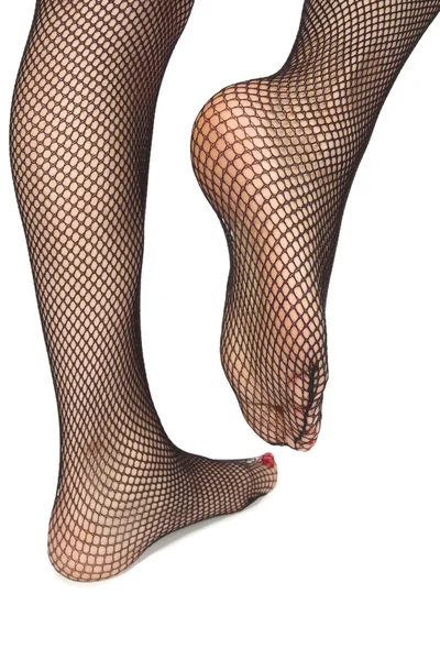 Woman feet with fishnet tights over white — Stock Photo, Image