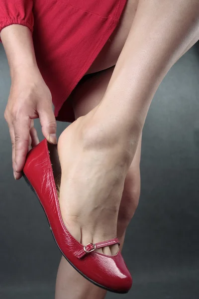 美丽的女人腿红色高跟鞋在灰色 — 图库照片
