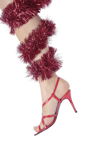 Pernas de mulher e saltos vermelhos com decorações de Natal sobre branco — Fotografia de Stock