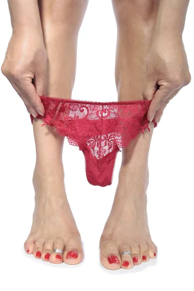 Сексуальные ноги снимают красное нижнее белье на белом фоне — стоковое фото
