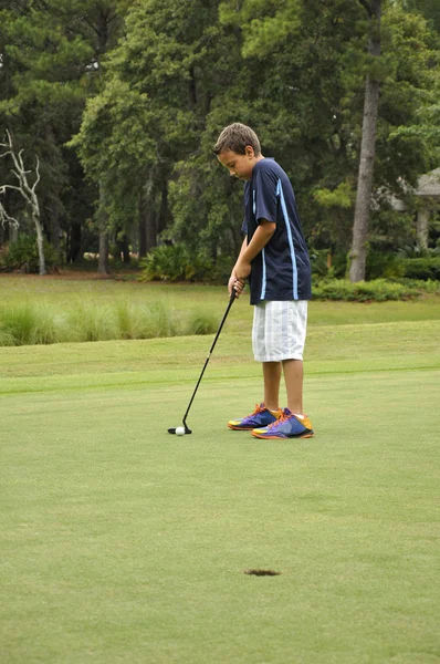 Młody chłopak gra w golfa — Zdjęcie stockowe