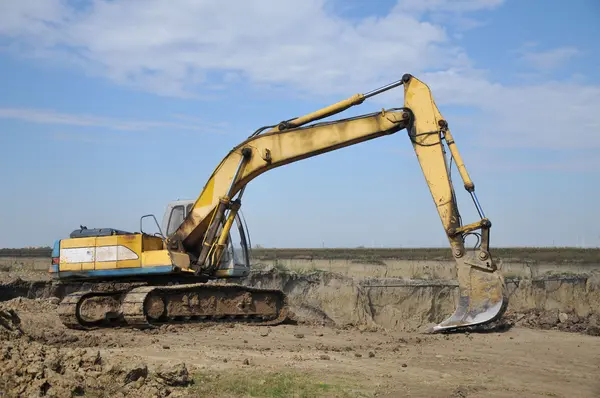 Excavadora amarilla en el sitio de construcción —  Fotos de Stock