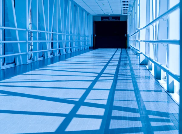 Täckt skywalk tunnel i en kall bluetone — Stockfoto