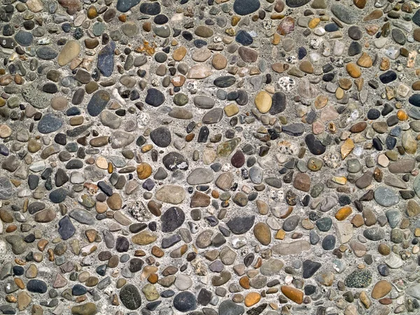 Concrete wall made of small river rocks — Stock Photo, Image
