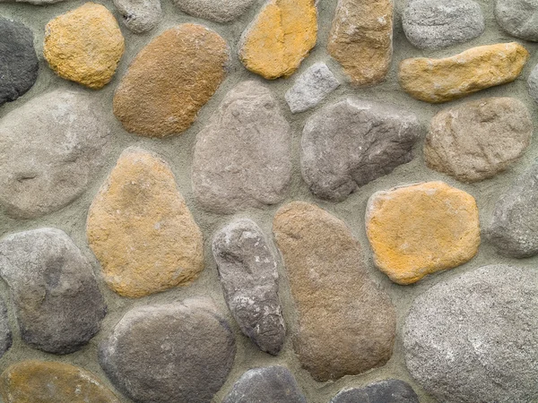 Rock en betonnen muur met grote afgeronde stenen — Stockfoto