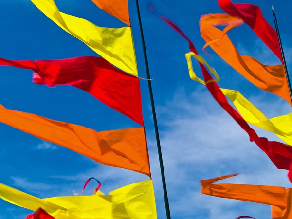Red, Orange, and Yellow Flags Waving in a Blue S — Stock Photo, Image