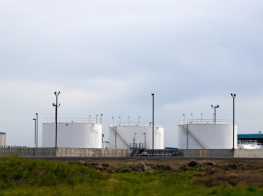 bulutlu bir gökyüzü ile bir alandaki beyaz yakıt tankları