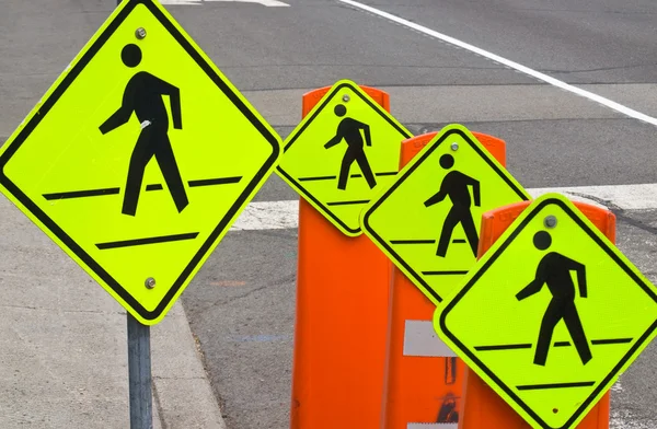 Чотири попереджувальні знаки руху пішоходів на сірій дорозі — стокове фото