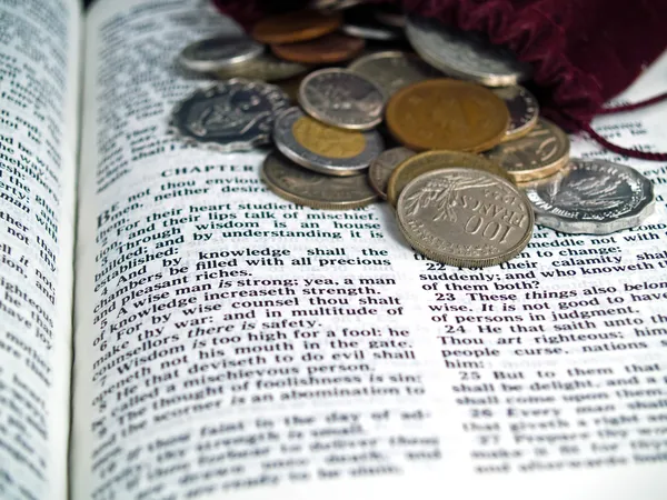 De Bijbel geopend aan het boek van spreuken met munten — Stockfoto