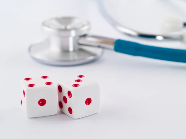 Stethoskop und Würfel als Glücksspiel mit Ihrem Gesundheitskonzept — Stockfoto