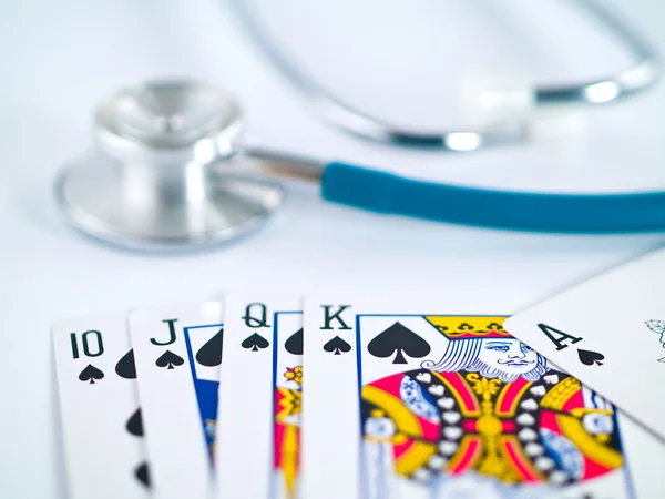 Stethoscoop en speelkaarten als een gokken met uw gezondheid concept — Stockfoto