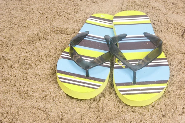 Zapatillas verdes de verano tumbadas sobre arena — Foto de Stock