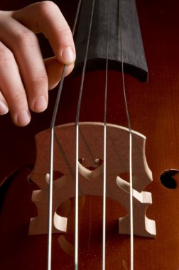 Close up of a childhand is playing the cello clipart
