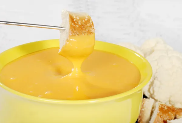 Bread dipped in cheese fondue — Stock Photo, Image