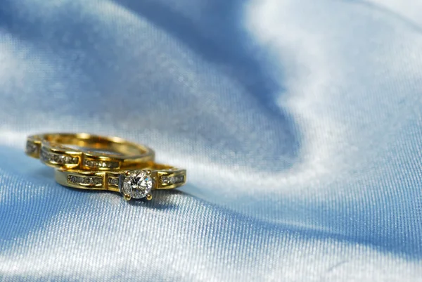 Diamantring met wedding band op blauw — Stockfoto