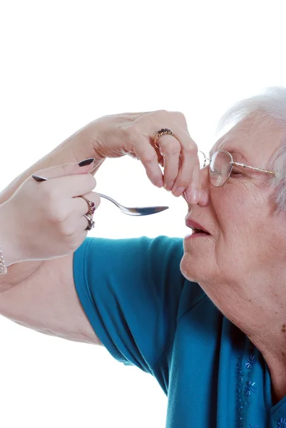 Elderly woman unhappy taking medication — Stock Photo, Image